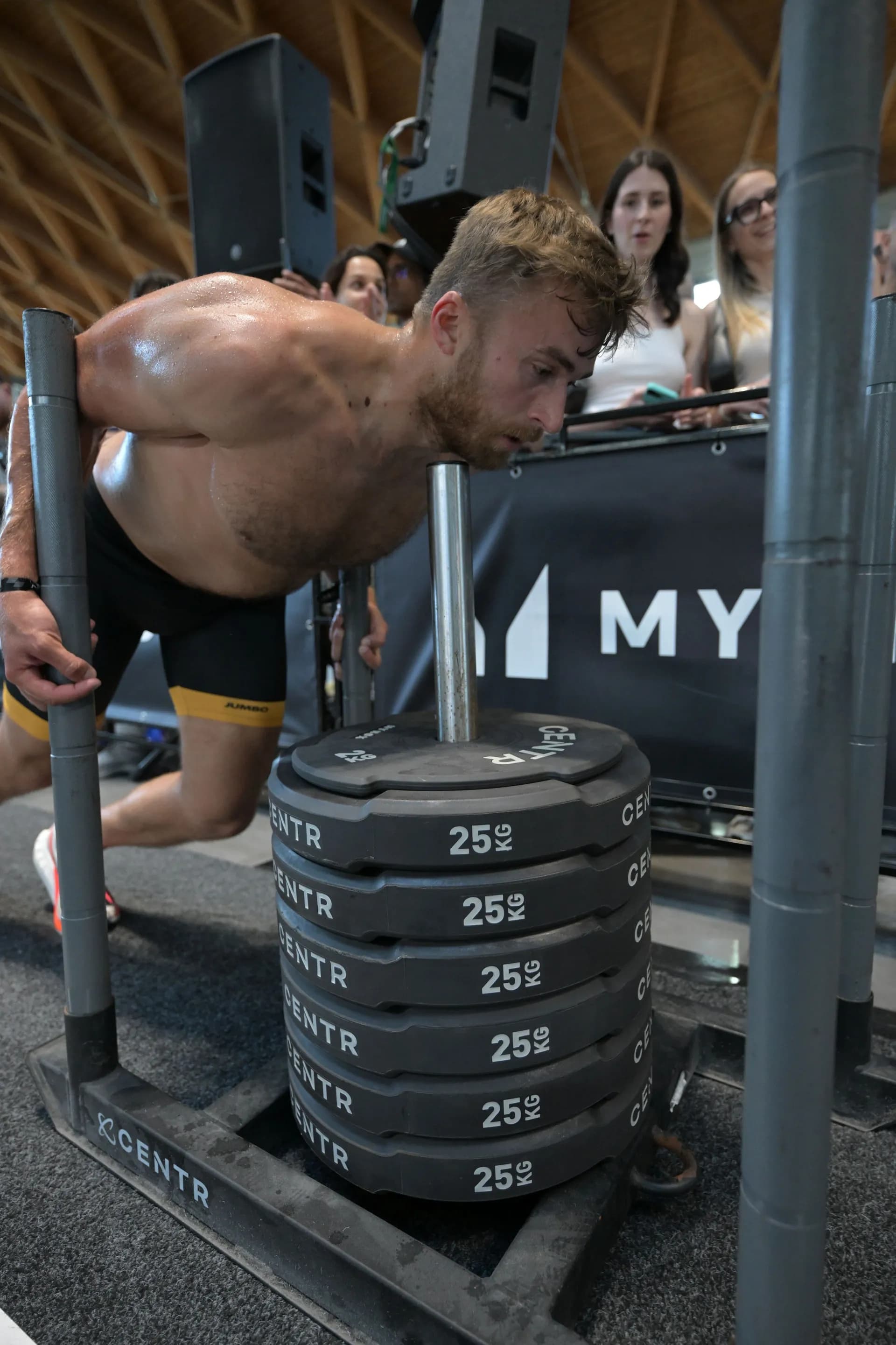 HYROX athlete driving the weighted sled push across the floor